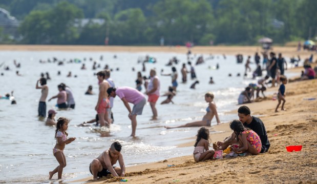 Beachgoers enjoy the Chesapeake Bay shoreline at Sandy Point State Park on a hot June afternoon.  (Jerry Jackson/Staff)